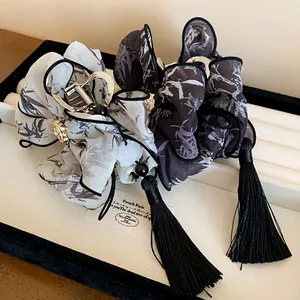 Detalle de pinzas para el cabello con lazo estilo chino, patrón de tinta y borlas