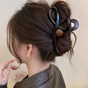 Détail d'une grande pince à cheveux style coréen avec perle ronde sur un chignon