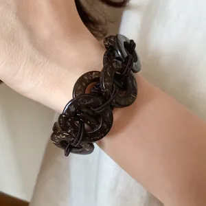 Vista dettagliata in primo piano di un bracciale etnico con dischi in guscio di cocco
