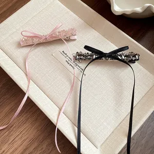 Gros plan détaillé de barrettes à ruban avec perles de verre et longs rubans soyeux.