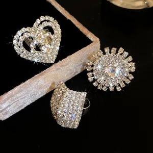 Dettaglio di lussuosi anelli con pavé di strass scintillanti a forma di cuore e fiore