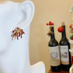 Elegant 18k gold plated fireworks stud earrings with red accents and zircons on ear