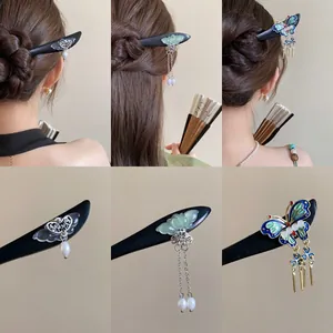Detail view of vintage wooden hairpins with butterfly and tassel accents for Hanfu.