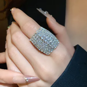 Primo piano di un anello aperto quadrato scintillante con strass al dito