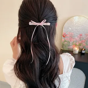 Gros plan détaillé d'une barrette à cheveux nœud rose avec perles de verre et rubans