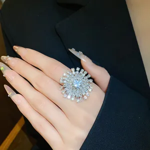 Dettaglio di uno splendente anello a raggiera con strass indossato su un dito molto elegante