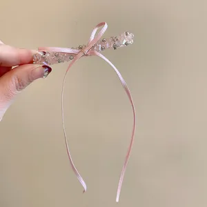 Vue détaillée d'une pince à cheveux en perles de verre rose avec un long nœud élégant