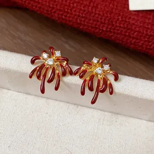 Close-up of unique red firework stud earrings with 18k gold plating and zircons.