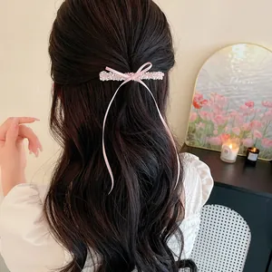 Détail d'une pince à cheveux rose avec perles brillantes sur cheveux ondulés