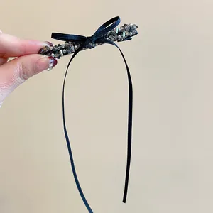 Vue détaillée d'une pince à cheveux à nœud noir ornée de perles de cristal gris foncé