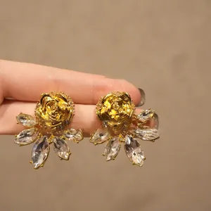 Primer plano de pendientes de rosa dorada vintage con elegantes cristales marquesa.