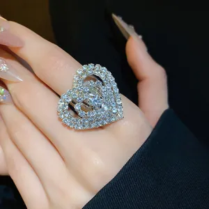 Dettaglio di un anello d'argento a doppio cuore con strass scintillanti sul dito