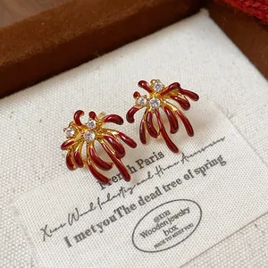 Macro detail of red and gold 18k gold plated firework stud earrings with zircon