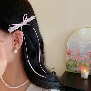 Détail d'une barrette à cheveux en perles de verre rose avec des rubans élégants