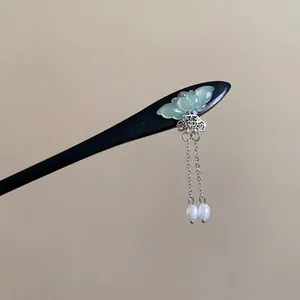 Detail of butterfly hair stick with dangling silver chains and white pearl beads