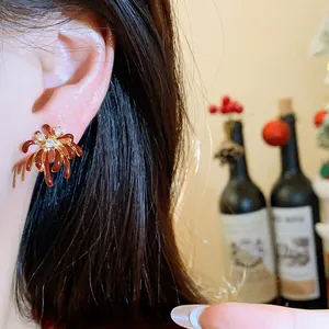 Detailed view of elegant red firework stud earrings with sparkling zircon centers on ear