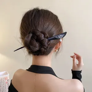 Close-up of a vintage Chinese style wooden hairpin with a butterfly and pearl drop