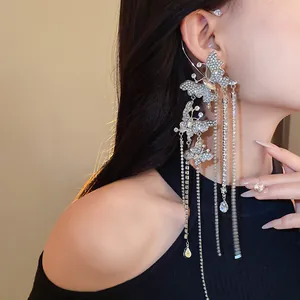 Detail of sparkling zircon butterfly ear cuff with long tassel on an Asian model.