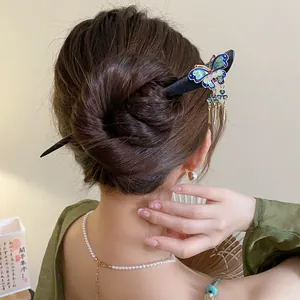 Detail view of an elegant butterfly wooden hair stick styled in a classic hair bun.