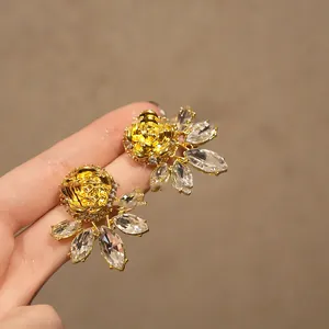 Detalle de pendientes vintage de rosa dorada con cristales en talla marquesa
