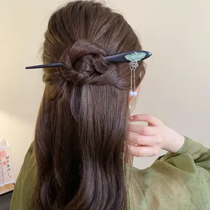 Elegant vintage wooden hair stick featuring a green butterfly ornament and pearl tassels in hair.