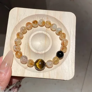 Primo piano del braccialetto vintage in perle di quarzo rutilato oro e occhio di tigre.