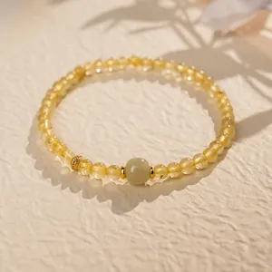 Primo piano di un bracciale vintage in cristallo di sole dorato e agata con ombre di foglie