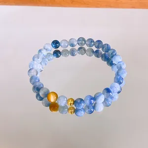 Vista dettagliata di un bracciale in cianite blu e pietra del sole su uno specchio.