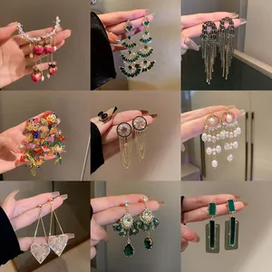 Showcase of nine elegant long drop earrings featuring crystals, pearls, and tassels