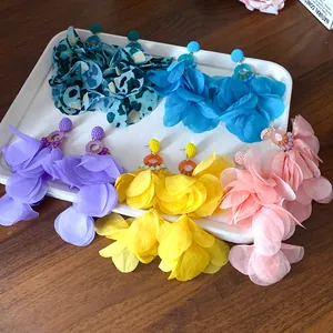 Orecchini pendenti a petali di stoffa colorata in cinque vivaci stili estivi da vacanza.
