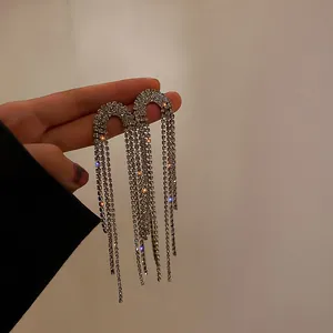 Detailed macro view of long rhinestone tassel earrings with sparkling silver finish