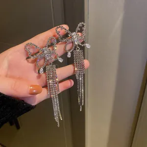 Detailed close-up of sparkling silver butterfly tassel earrings with rhinestones