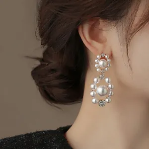 Detailed close-up showing elegant double-circle pearl and zircon earrings worn on an ear