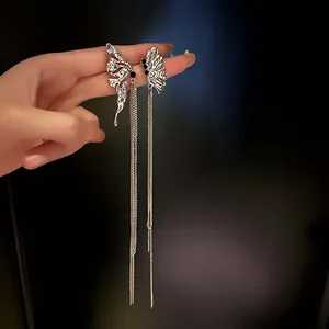 Detailed macro view of silver liquid butterfly long tassel earrings with black stones