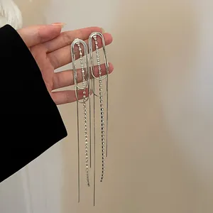 Close-up of silver-tone tassel earrings with cascading rhinestone chains and studs