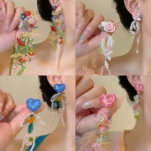 Detail view of colorful glass heart and flower drop earrings for a dopamine look