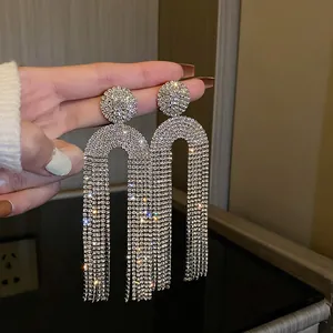 Close-up of exaggerated silver fringe earrings with shimmering full rhinestones