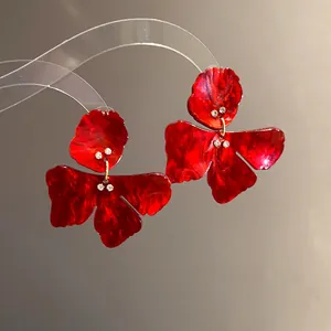 Detailed view of elegant red marbled resin flower stud earrings with tiny rhinestones