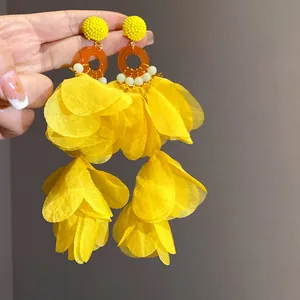Dettaglio degli orecchini con nappe a petalo giallo vibrante stile vacanza al mare