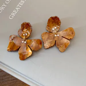 Macro view of vintage resin flower stud earrings with delicate sparkling rhinestones