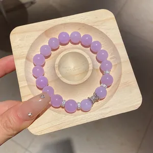 Élégant bracelet en perles d'agate lavande avec un pendentif papillon brillant sur bois