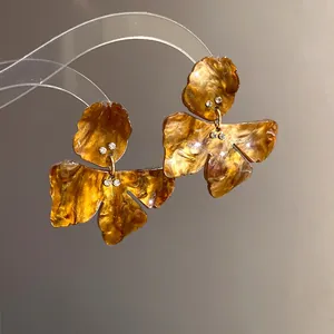 Detailed view of elegant amber resin flower earrings featuring delicate rhinestones