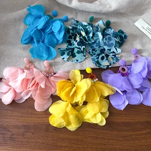 Dettaglio di orecchini bohémien con petali di fiori in tessuto in vari colori