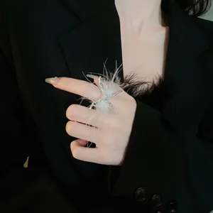 Elegante anillo abierto plateado con diseño de mariposa y delicadas plumas blancas