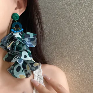 Dettaglio orecchini a nappa con petali in tessuto stampa leopardata blu e verde