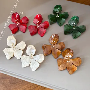 Close-up detail of oversized resin flower stud earrings with marbleized textures