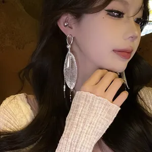 Detalle de elegantes pendientes de malla con perlas usados por una modelo