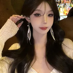 Elegantes pendientes de gota de malla plateada con perlas y borlas en una modelo