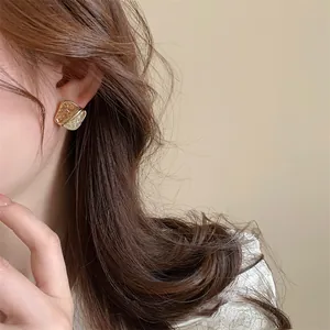Close-up view of elegant square color-block crystal stud earrings worn by an Asian model