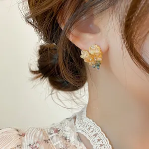 Detail view of heart-shaped crystal stud earrings worn on ear